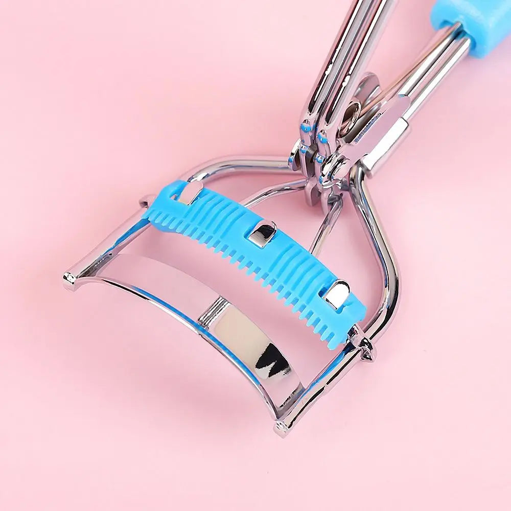 A close-up of a stainless steel eyelash curler with a blue plastic comb and metal clamp.