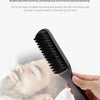 A hand holds a black boar bristle brush, demonstrating its use for a smooth shave on a man's face.