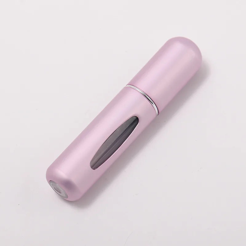 A pink portable refillable perfume bottle with a silver band, shown in a diagonal view.