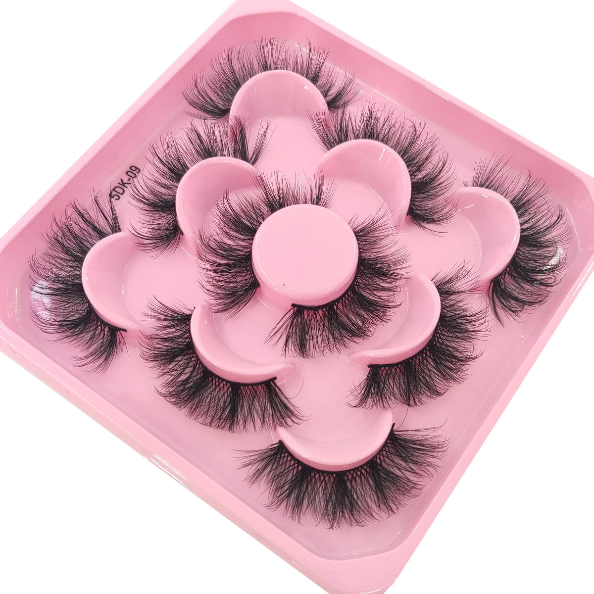 A pink plastic tray holding a set of black artificial mink eyelashes.