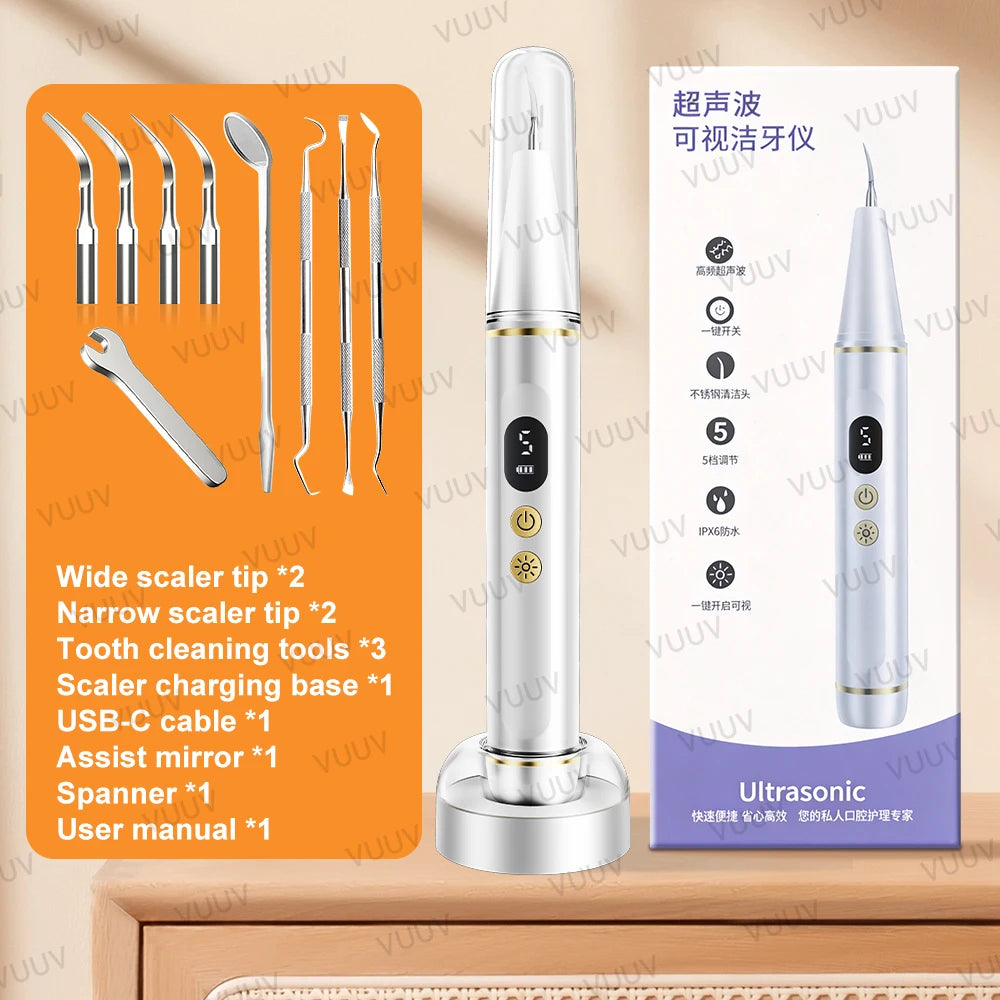A silver ultrasonic dental scaler device with various tips and accessories displayed on a wooden surface.