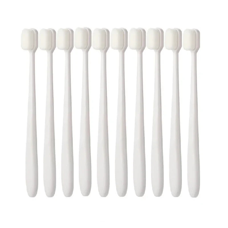 A set of ten white ultra-fine bristle toothbrushes arranged in a row.