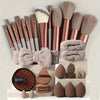 A collection of beauty sponges and brushes in various shades of beige and rose gold are displayed on a white surface.