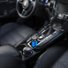 Close-up view of a portable electric shaver with a blue handle resting in a car interior
