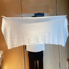 A white extra large disposable towel is displayed flat against a wooden cabinet.