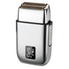 A silver electric shaver with a textured head and a digital display showing 100% power level.