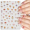 A close-up of a hand displaying various watercolor mushroom nail art stickers on fingernails.