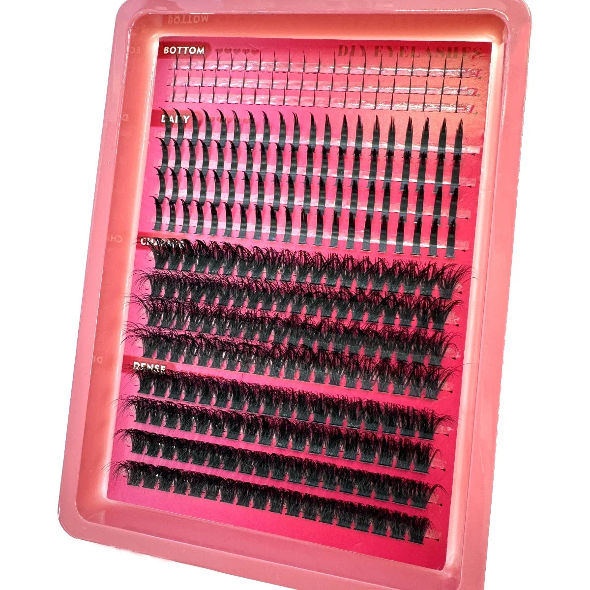 A pink plastic tray containing various lash clusters for DIY eyelash extensions, including bottom, spikes, and dense styles.