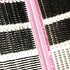 A pink plastic kit containing various false eyelash extensions and lash tools for DIY use
