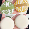 A set of air cushion makeup puffs in olive green and yellow with a storage box.