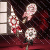 A silver pearl hand mirror with a pink bow rests on a red velvet surface.