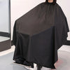 Un tablier professionnel noir pour la coupe de cheveux drapé sur un mannequin.