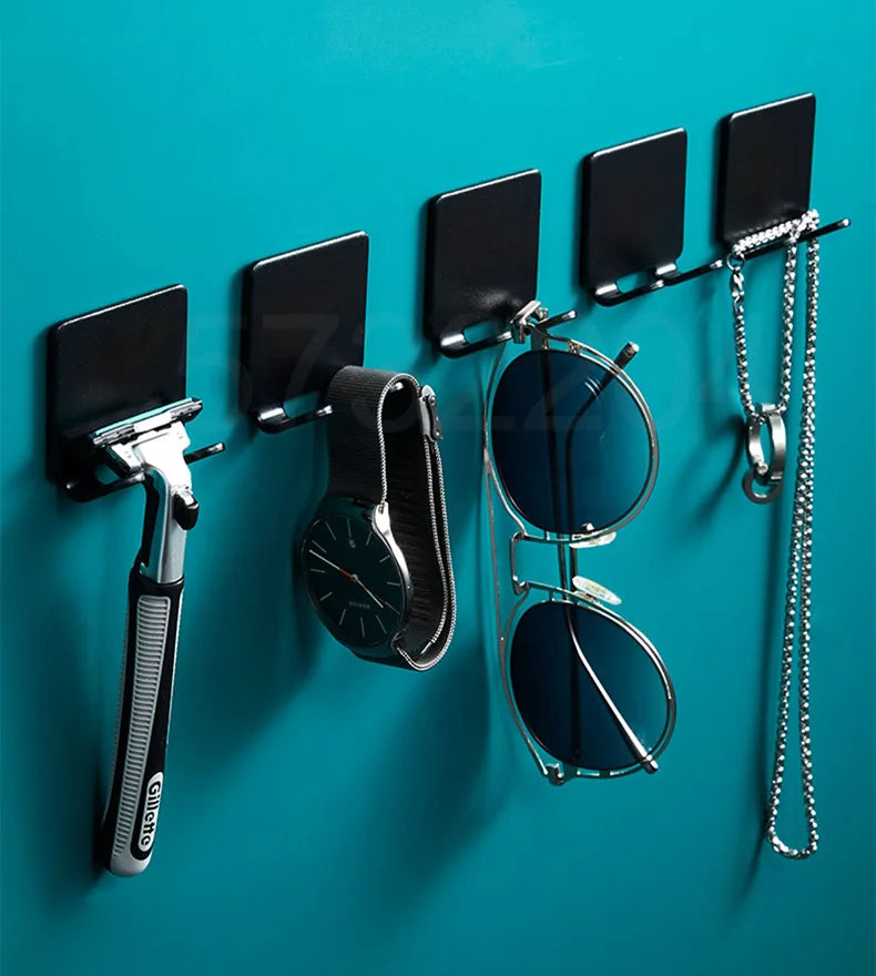 Support à rasoir multifonction noir avec plusieurs emplacements et une paire de lunettes contre un fond bleu sarcelle