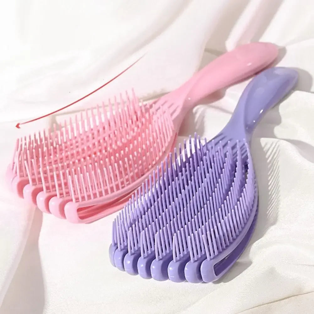 A pink massage detangler hair brush for curly and thick hair is shown against a white background.