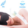 A woman is sleeping with a black 3D contoured sleep mask on her eyes, demonstrating silky and breathable features.
