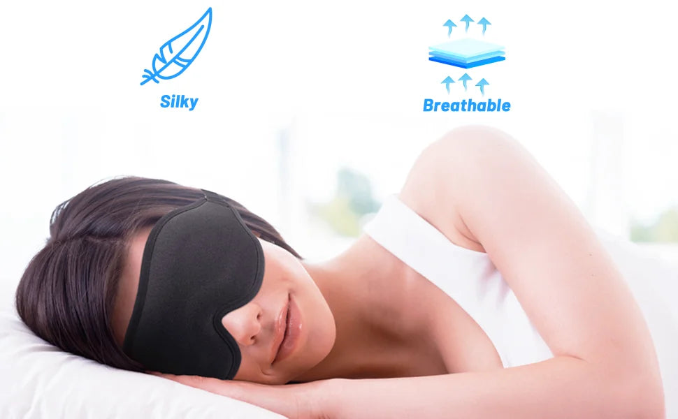 A woman is sleeping with a black 3D contoured sleep mask on her eyes, demonstrating silky and breathable features.