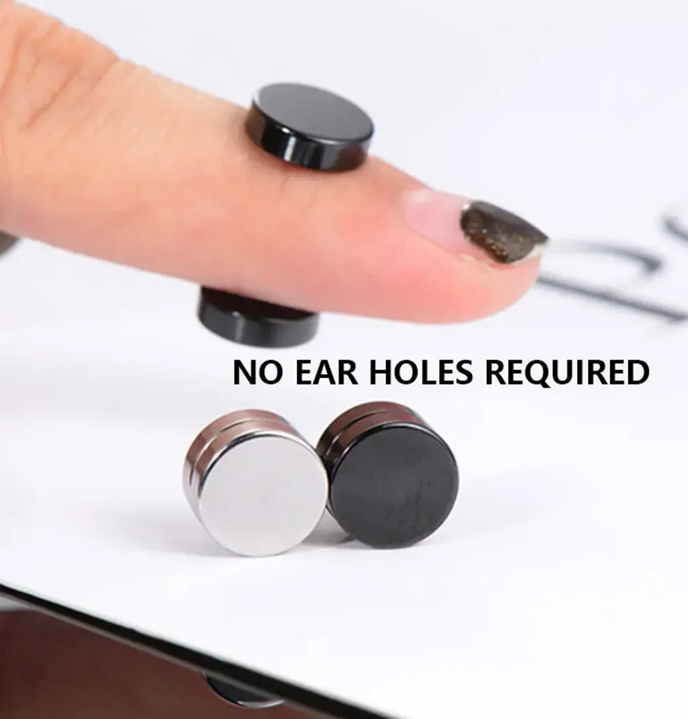 Close-up of black magnetic stud earrings being placed on a finger, showing the size and finish.