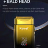 A gold-colored electric reciprocating shaver with a black body is shown on a dark surface.