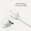 A white toothbrush with a bristle tip treatment shown next to a magnified view of the brush head.