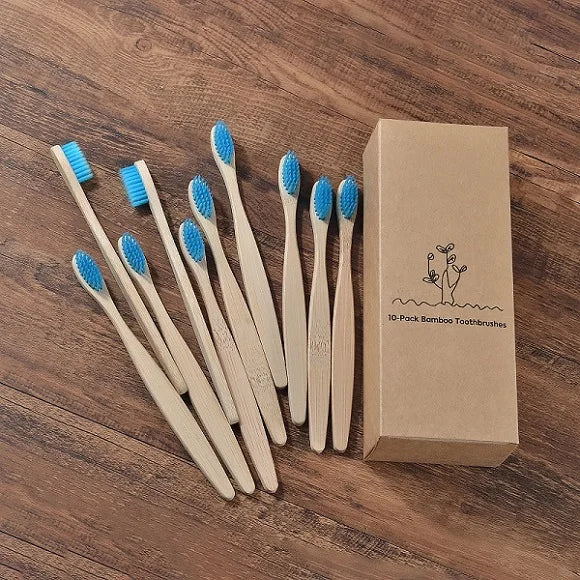 Une boîte contenant dix brosses à dents en bambou posées sur une surface en bois.