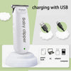 A white Baby clipper is shown charging with a USB cable, placed on a white charging base.