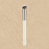 A single professional makeup brush with a silver ferrule and white handle set against a beige background.