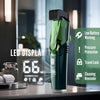 A close-up of a green cordless beard trimmer with a LED display resting on a counter.