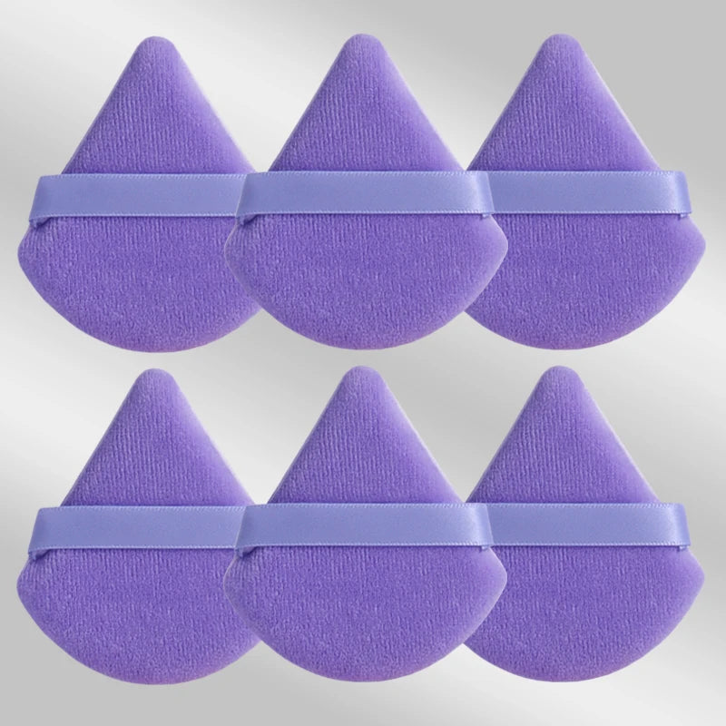 Un ensemble de six puffs de maquillage triangulaires violettes avec des bandes lavande.