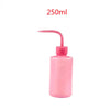 A pink plastic bottle for eyelash extension cleaning with a precision applicator brush.