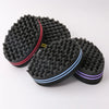 A black dual-sided hair braiding brush with a textured surface and colored accents.