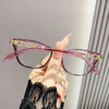 Une main tient des lunettes à œil de chat roses élégantes avec des accents dorés sur un fond clair.