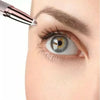 A close-up of an eyebrow being shaped by a portable electric trimmer near a woman's eye.