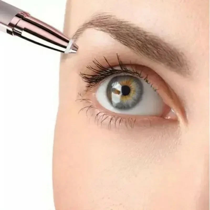 A close-up of an eyebrow being shaped by a portable electric trimmer near a woman's eye.