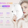 A woman applies a white touch screen facial LED mask for skincare treatments.