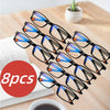 A set of eight black-framed multifocal reading glasses with blue and orange lenses displayed on a wooden surface.