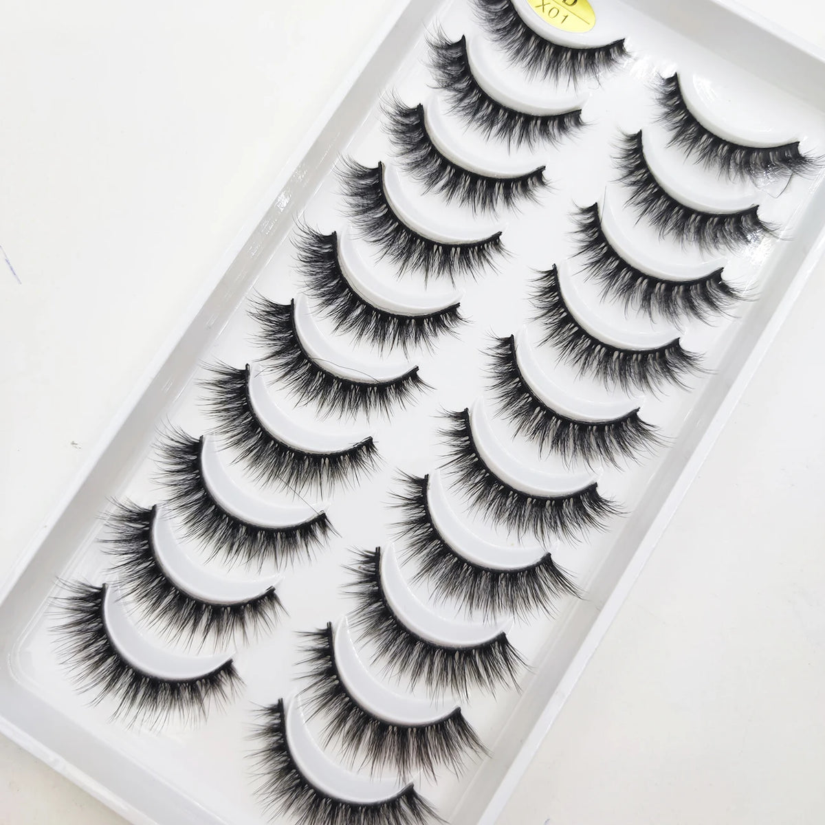 A plastic tray holding multiple pairs of black natural 3D mink false eyelashes.