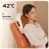 A woman is using a portable shiatsu neck massager pillow on her neck in a bright indoor setting.