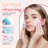 A woman gently cleans her face using a silicone facial cleansing brush set with a white and pink applicator.