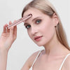 A woman is using a pink electric eyebrow trimmer to create an eyebrow shape on her face.