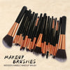 A collection of 22 professional makeup brushes with wooden handles and synthetic bristles arranged diagonally on a light back