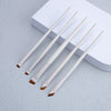 A set of five white precision eyeliner application brushes resting on a white rectangular box.