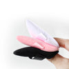 A hand holds a set of reusable velvet powder puffs in pink and black.