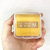 A hand holds an air cushion makeup puff set with a clear storage box containing yellow makeup puffs.