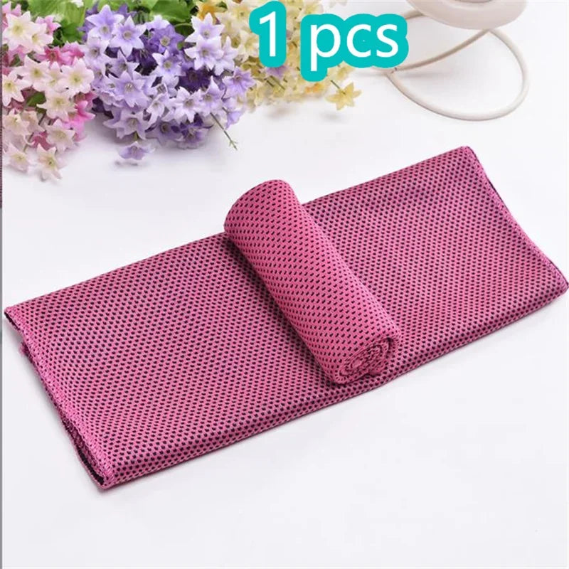 A pink mesh sport towel rolled up on a white surface next to purple and yellow flowers.