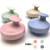 A set of silicone body and scalp massage brushes in pink, green, and blue tones.