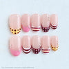 A set of ten pink press-on nails featuring a polka dot pattern and silver bead accents.