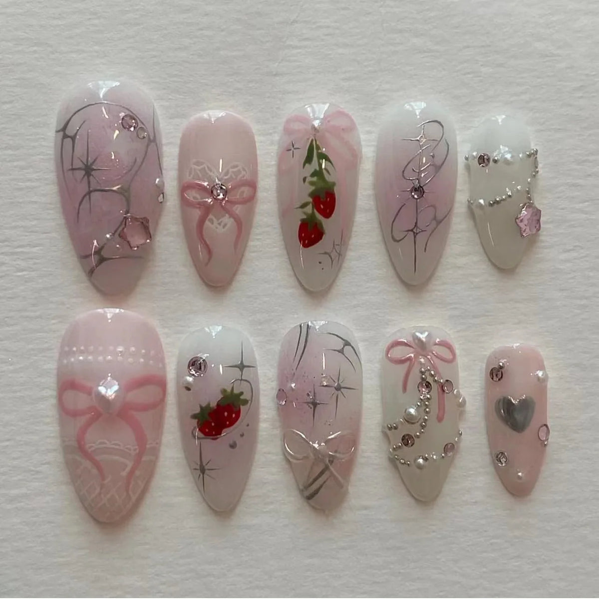 A collection of 24 pink heart pearl press-on fake nails featuring various designs including glitter and floral accents.