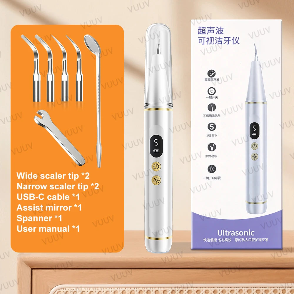 A white ultrasonic dental scaler tool and various accessories are displayed on a wooden surface.