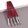 A set of nine precision makeup brushes in red and silver handles with fluffy pink bristles.
