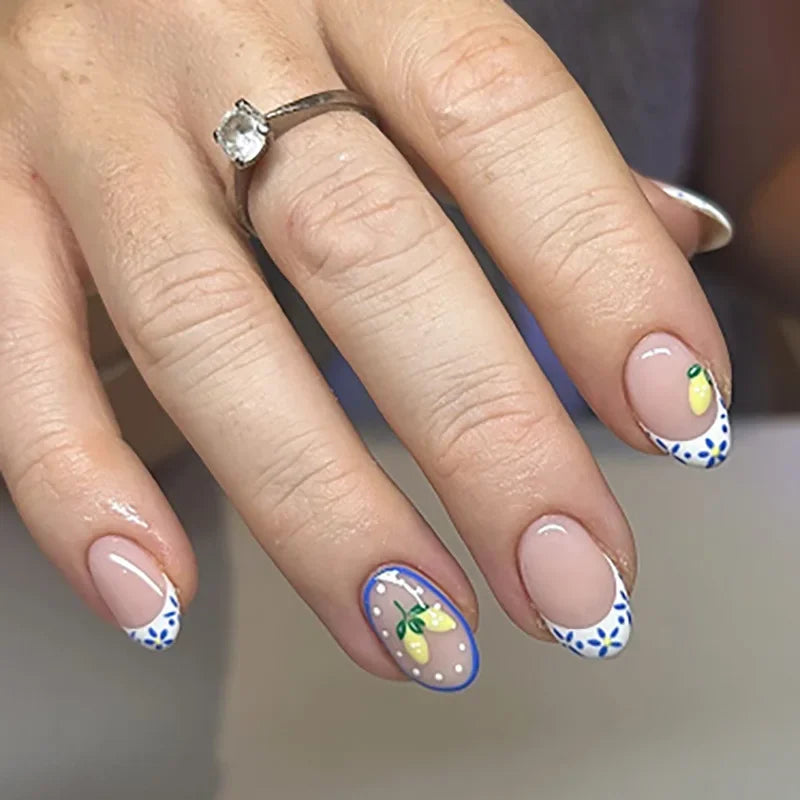 Une main montrant des kits de vernis à ongles fleurs d'amande pressées avec des motifs floraux délicats et une bague en argen